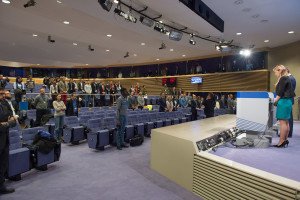 The journalists in the press room of the EC and Mina Andreeva, Deputy Chief Spokesperson of the EC, at the podium, observing one minute of silence in tribute to the victims