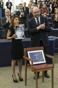 Ensaf Haidar, on the left, holding a photograph of her husband, Raif Badawi, 2015 Sakharov Prize for Freedom of Thought Laureate, applauded by Martin Schulz, on the right (in the foreground)